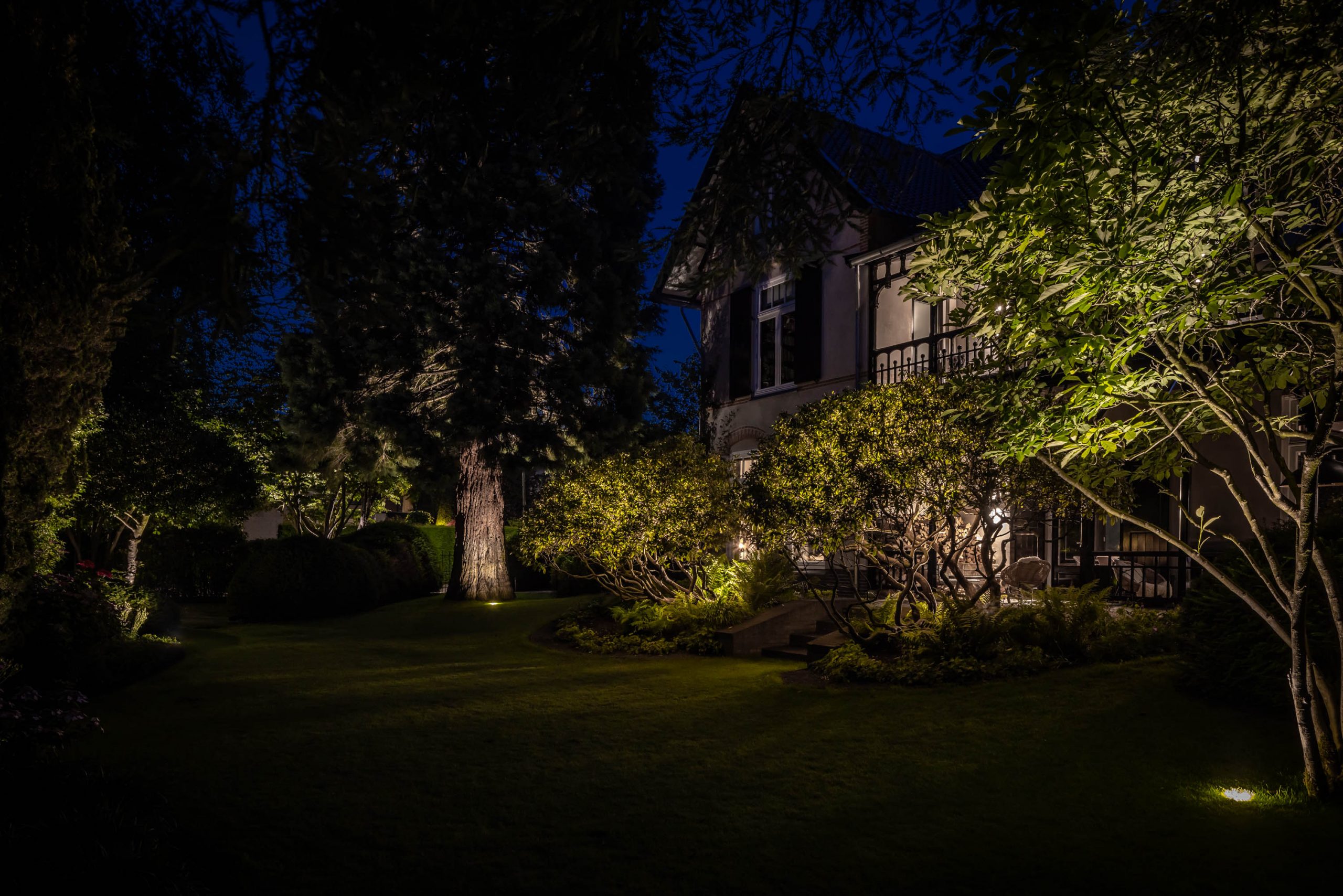 Herenvilla en tuin smelten samen door de sfeervolle buitenverlichting